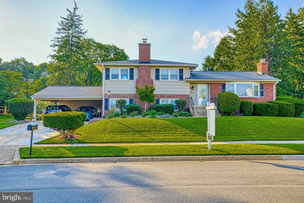 912 Fairway Dr NE, Vienna, VA 22180 - tri-level home with a chimney, a front yard, driveway, and brick siding