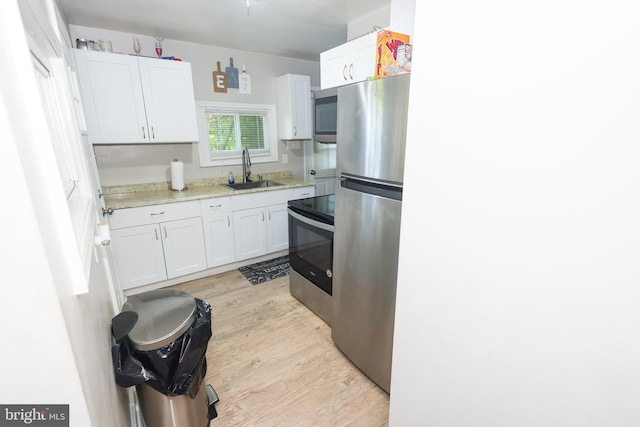 1675 Highland Ter, Saint Leonard, MD 20685 - kitchen featuring appliances with stainless steel finishes, a sink, white cabinets, and light wood-type flooring