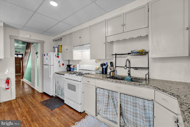 314 Summit Ave, Reading, PA 19611 - kitchen with white appliances, a sink, under cabinet range hood, wood finished floors, and a paneled ceiling