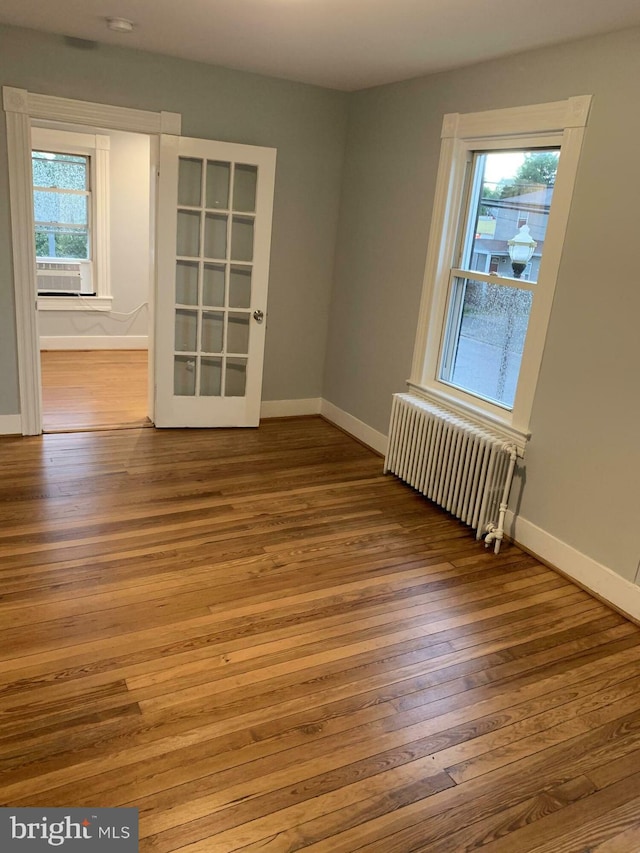 120 2nd St, Laurel, MD 20707 - empty room with radiator heating unit, plenty of natural light, hardwood / wood-style floors, and baseboards