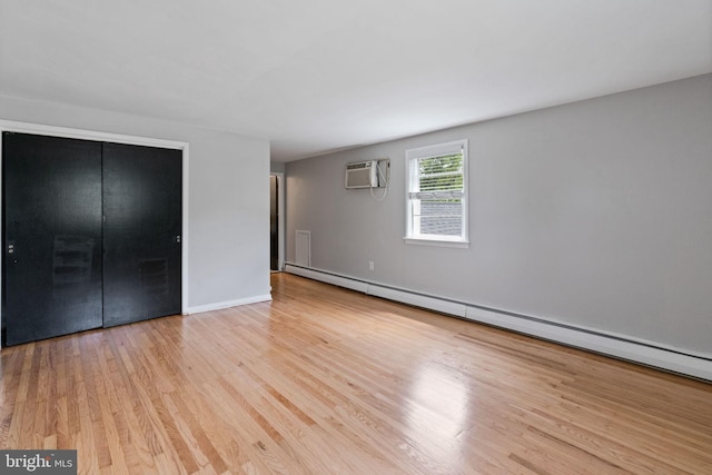2958 Hannah Ave, Norristown, PA 19401 - unfurnished bedroom with wood finished floors, a baseboard heating unit, a wall mounted AC, a closet, and baseboards