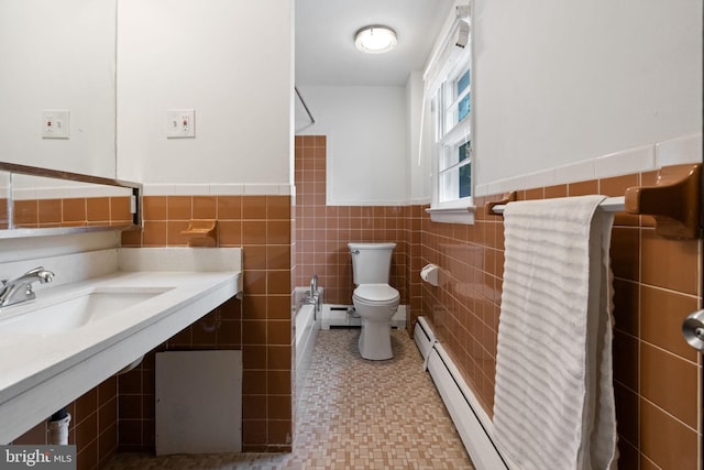 2958 Hannah Ave, Norristown, PA 19401 - bathroom featuring toilet, a sink, tile walls, baseboard heating, and a wainscoted wall