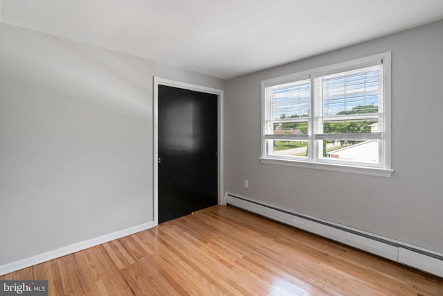 2958 Hannah Ave, Norristown, PA 19401 - unfurnished bedroom featuring a baseboard heating unit, light wood-type flooring, and baseboards