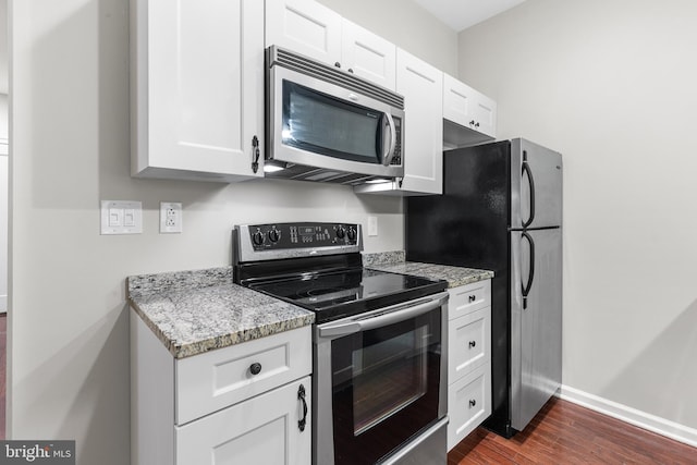 1811 Chestnut St Unit 104, Philadelphia, PA 19103 - kitchen featuring appliances with stainless steel finishes, dark wood-type flooring, white cabinetry, and light stone countertops