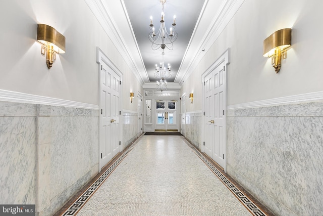 1811 Chestnut St Unit 104, Philadelphia, PA 19103 - hallway with a chandelier, inlaid floor details, a wainscoted wall, ornamental molding, and tile walls