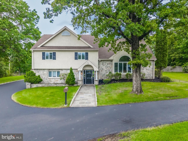23 Street Rd, Newtown Square, PA 19073 - view of front of property with stucco siding, stone siding, a front lawn, and a shingled roof