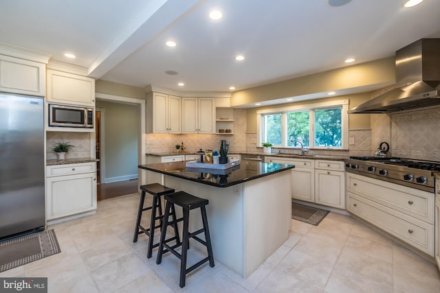 23 Street Rd, Newtown Square, PA 19073 - kitchen with appliances with stainless steel finishes, wall chimney range hood, tasteful backsplash, a sink, and a breakfast bar area