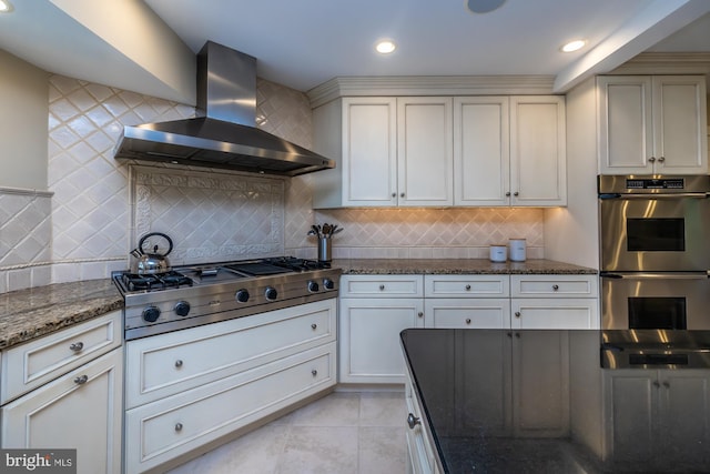 23 Street Rd, Newtown Square, PA 19073 - kitchen featuring stainless steel appliances, wall chimney range hood, dark stone countertops, decorative backsplash, and light tile patterned floors