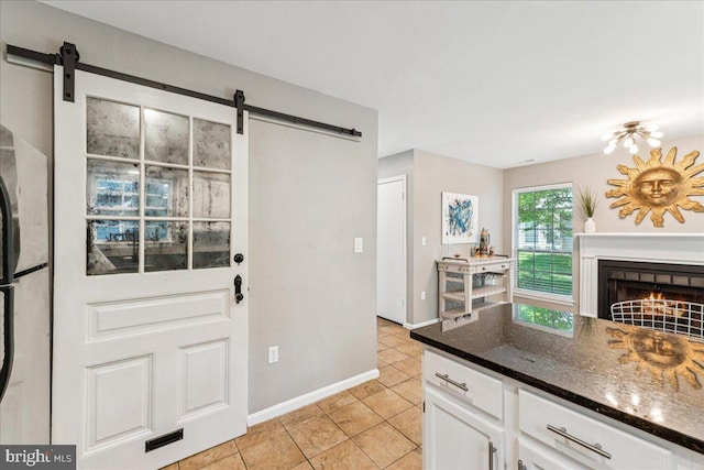 963 Breakwater Dr, Annapolis, MD 21403 - kitchen featuring a barn door, white cabinetry, dark stone counters, light tile patterned flooring, and freestanding refrigerator