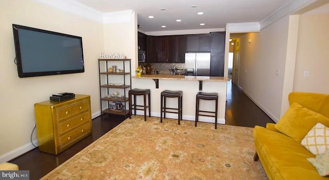7524 Morris St Unit 5, Fulton, MD 20759 - kitchen featuring appliances with stainless steel finishes, a kitchen breakfast bar, dark brown cabinets, tasteful backsplash, and baseboards