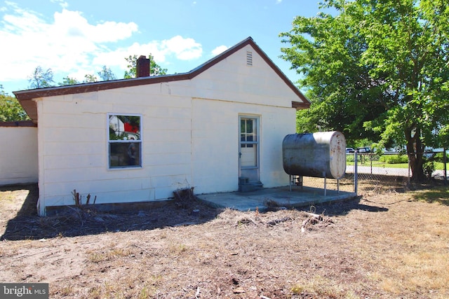515 Burton Ave, Cambridge, MD 21613 - view of side of property featuring oil tank, a chimney, and a patio area