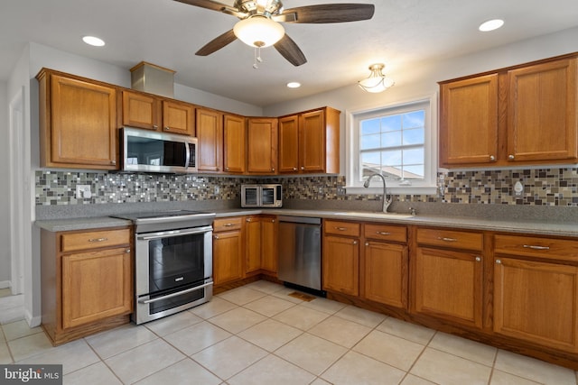 90 Hummingbird Ln, Littlestown, PA 17340 - kitchen with appliances with stainless steel finishes, brown cabinetry, and decorative backsplash