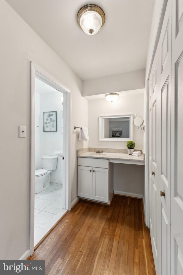 11706 Milbern Dr, Rockville, MD 20854 - bathroom featuring toilet, hardwood / wood-style floors, vanity, and baseboards