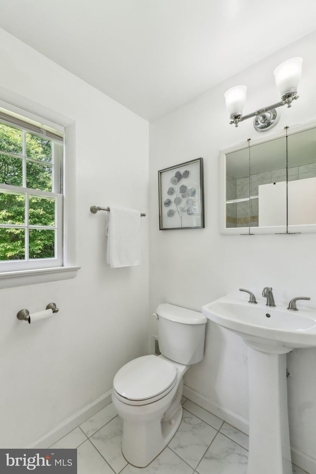 11706 Milbern Dr, Rockville, MD 20854 - bathroom featuring toilet, marble look tiles, baseboards, and a sink