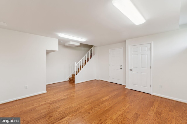 11706 Milbern Dr, Rockville, MD 20854 - finished basement with light wood-style flooring, stairs, and baseboards