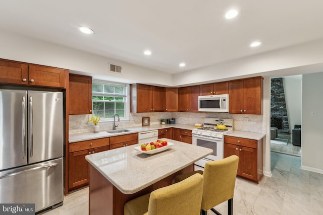 11706 Milbern Dr, Rockville, MD 20854 - kitchen featuring white appliances, a sink, a kitchen island, a breakfast bar, and decorative backsplash