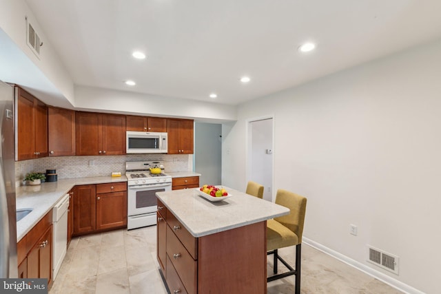 11706 Milbern Dr, Rockville, MD 20854 - kitchen with white appliances, a center island, a breakfast bar area, tasteful backsplash, and recessed lighting