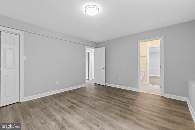 7102 Walnut Ave, Baltimore, MD 21208 - unfurnished bedroom featuring wood finished floors, baseboards, and ensuite bathroom