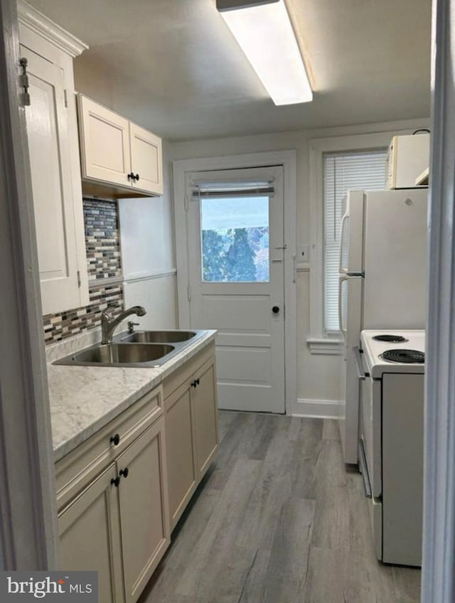250 E E Main St, Waynesboro, PA 17268 - kitchen featuring white electric range oven, a sink, light countertops, decorative backsplash, and light wood finished floors