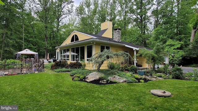212 Haag Rd, Reading, PA 19606 - rear view of property with a gazebo, a lawn, a chimney, and a sunroom