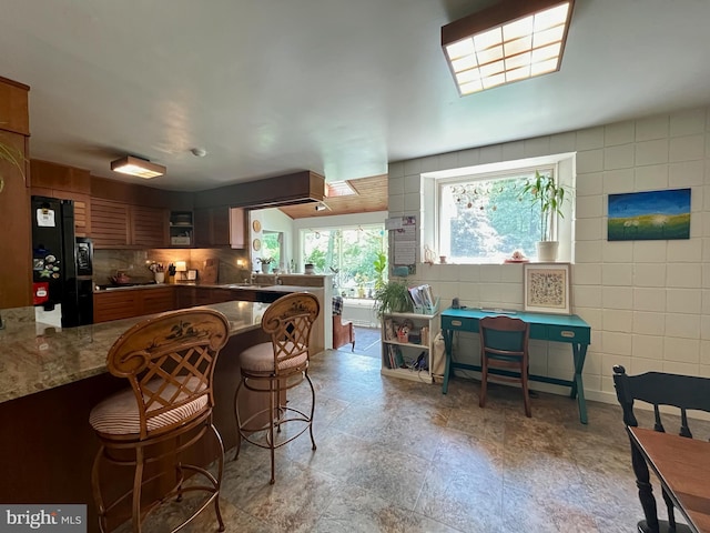 212 Haag Rd, Reading, PA 19606 - kitchen with a peninsula, a sink, freestanding refrigerator, a kitchen breakfast bar, and brown cabinets