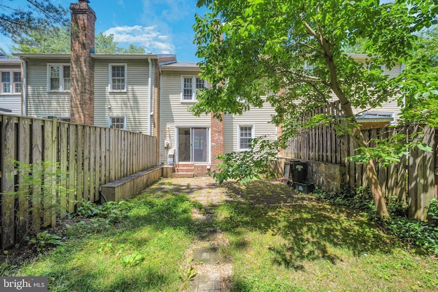 8361 Luce Ct, Springfield, VA 22153 - rear view of property featuring entry steps, a chimney, and a fenced backyard