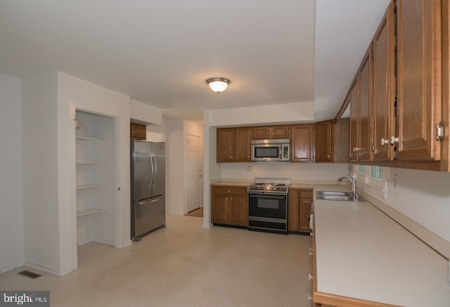 9 Paddington Ct, Hockessin, DE 19707 - kitchen featuring appliances with stainless steel finishes, a sink, brown cabinets, and light countertops