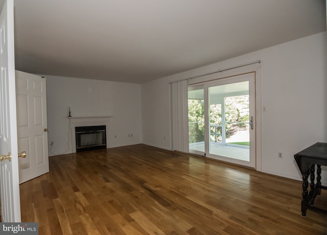 9 Paddington Ct, Hockessin, DE 19707 - unfurnished living room with wood finished floors, a glass covered fireplace, and baseboards