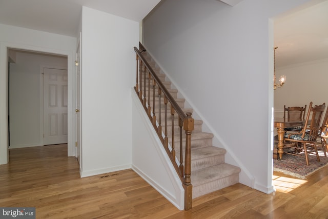 9 Paddington Ct, Hockessin, DE 19707 - stairway featuring wood finished floors, a chandelier, and baseboards