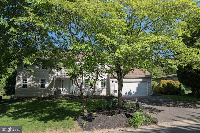 9 Paddington Ct, Hockessin, DE 19707 - view of property hidden behind natural elements with driveway, a front yard, a garage, and a porch