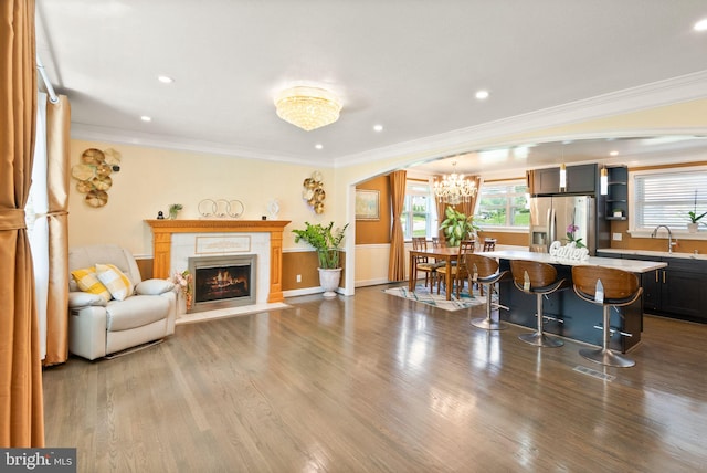 7434 Dickenson St, Springfield, VA 22150 - living room with crown molding, arched walkways, a chandelier, a fireplace, and dark wood finished floors