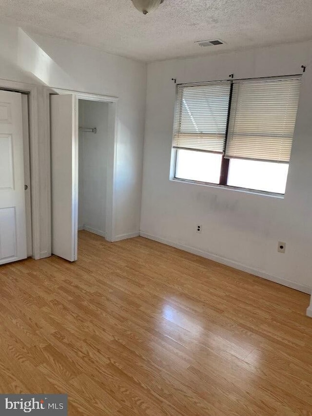 2600 S Mildred St, Philadelphia, PA 19148 - unfurnished bedroom with a textured ceiling, light wood-style flooring, baseboards, and two closets