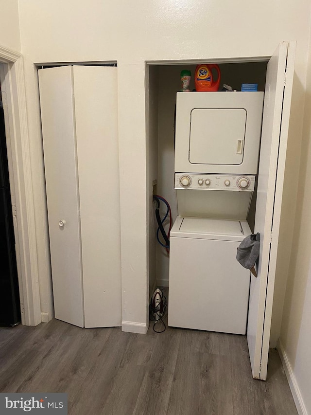 2600 S Mildred St, Philadelphia, PA 19148 - laundry room featuring stacked washer and clothes dryer, dark wood-style floors, and baseboards
