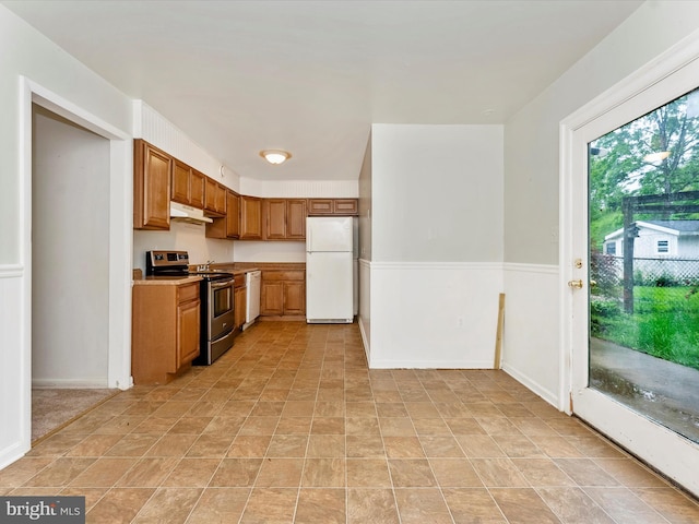 7324 E Springbrook Ct, Middletown, MD 21769 - kitchen with white appliances, under cabinet range hood, light countertops, brown cabinets, and a wainscoted wall