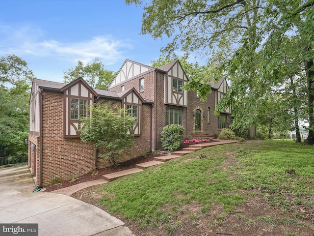 1316 Swan Harbour Rd, Fort Washington, MD 20744 - tudor home featuring brick siding, a front yard, and driveway