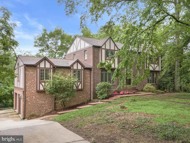 1316 Swan Harbour Rd, Fort Washington, MD 20744 - tudor home featuring brick siding, driveway, an attached garage, and a front yard