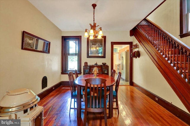 315 Nevin St, Lancaster, PA 17603 - dining area with a chandelier, wood-type flooring, stairway, and baseboards