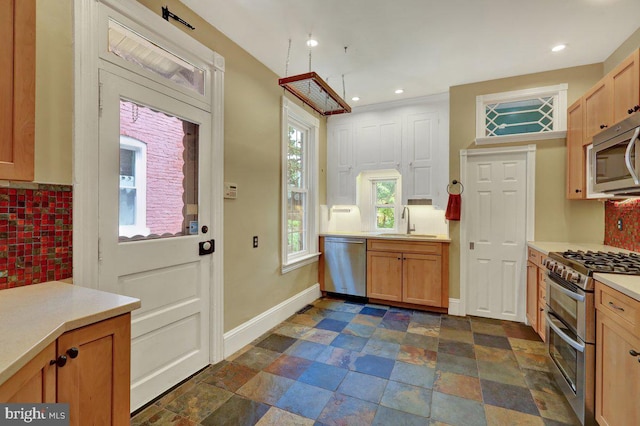 315 Nevin St, Lancaster, PA 17603 - kitchen with stainless steel appliances, a sink, backsplash, light countertops, and dark stone finish flooring