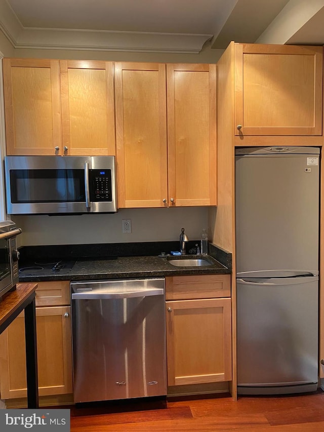 1121 24th St NW Unit 310, Washington, DC 20037 - kitchen with stainless steel appliances, wood finished floors, a sink, and light brown cabinetry