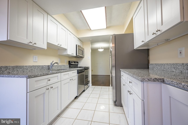 4500 Four Mile Run Dr Unit 211, Arlington, VA 22204 - kitchen with stainless steel appliances, white cabinets, a sink, and light tile patterned flooring