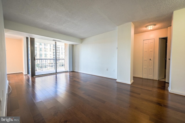 4500 Four Mile Run Dr Unit 211, Arlington, VA 22204 - empty room featuring a textured ceiling, dark wood finished floors, baseboards, and a wall of windows