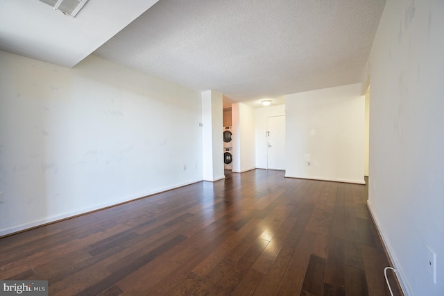 4500 Four Mile Run Dr Unit 211, Arlington, VA 22204 - unfurnished living room with dark wood finished floors, stacked washer and clothes dryer, a textured ceiling, and baseboards