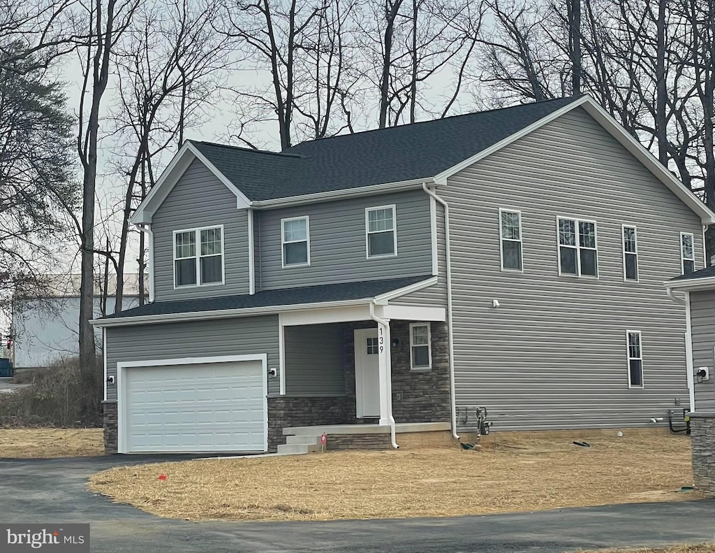 8917 Lennings Ln, Rosedale, MD 21237 - view of front facade featuring covered porch, driveway, a garage, and stone siding