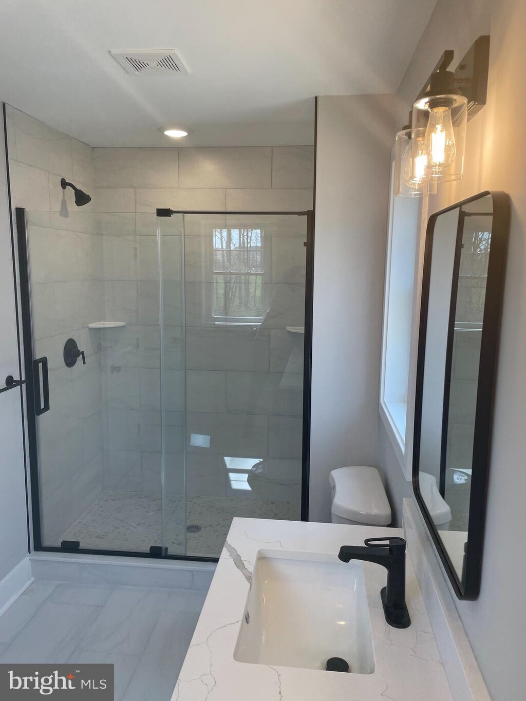 8917 Lennings Ln, Rosedale, MD 21237 - full bathroom featuring marble look tile flooring, toilet, a shower stall, and vanity