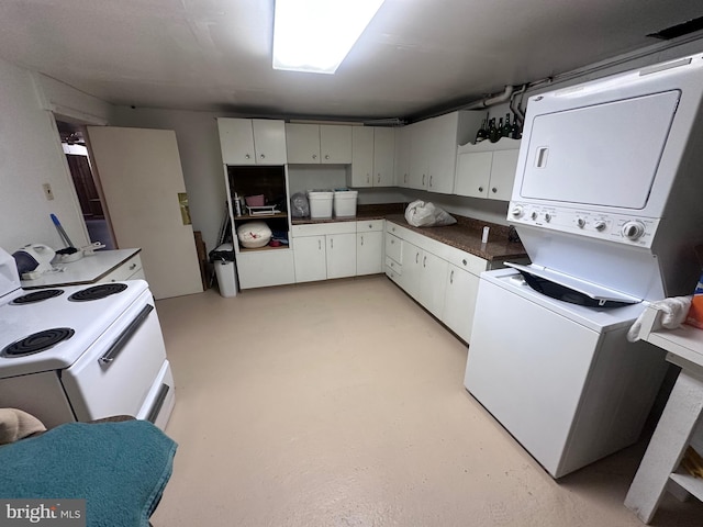 23 N Valley View Ln, Keyser, WV 26726 - kitchen with stacked washing machine and dryer, dark countertops, white range with electric cooktop, white cabinetry, and concrete floors