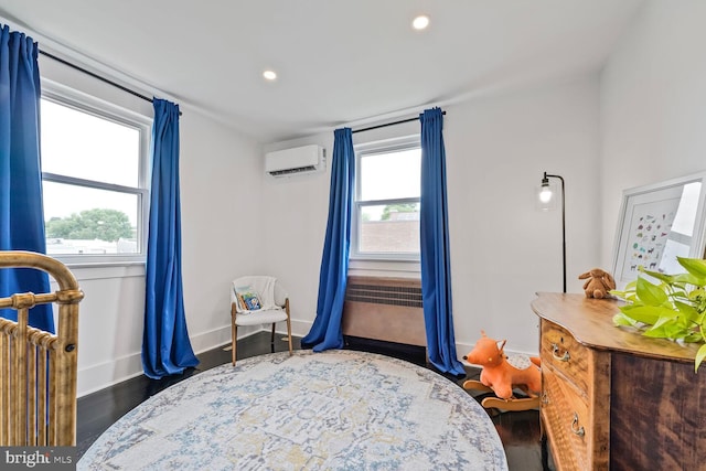 5319 Ames St NE, Washington, DC 20019 - bedroom with a wall mounted air conditioner, recessed lighting, wood finished floors, and baseboards