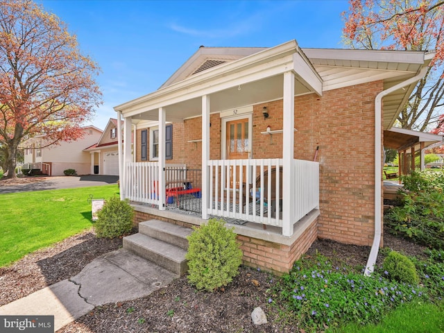 52 Circle Dr, Ephrata, PA 17522 - view of front facade featuring covered porch, brick siding, and a front lawn