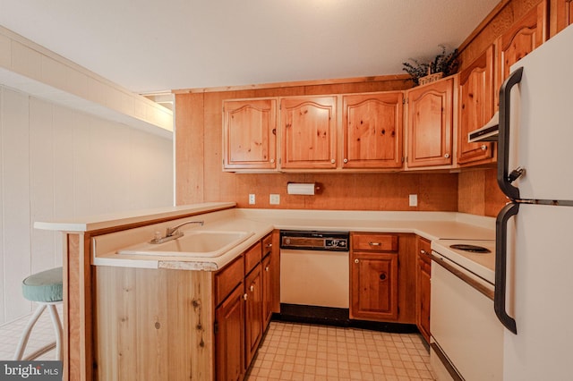 38395 Cardinal Ln Unit 184, Selbyville, DE 19975 - kitchen with white appliances, a peninsula, light countertops, light floors, and brown cabinetry