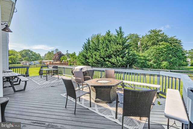 5040 Hummingbird Ln, Warrenton, VA 20187 - wooden terrace with a fire pit, a lawn, and view of wooded area