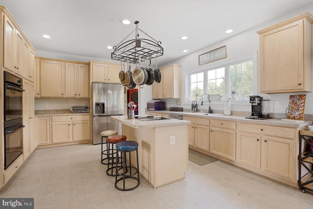 5040 Hummingbird Ln, Warrenton, VA 20187 - kitchen featuring black appliances, light brown cabinetry, a sink, a breakfast bar area, and recessed lighting